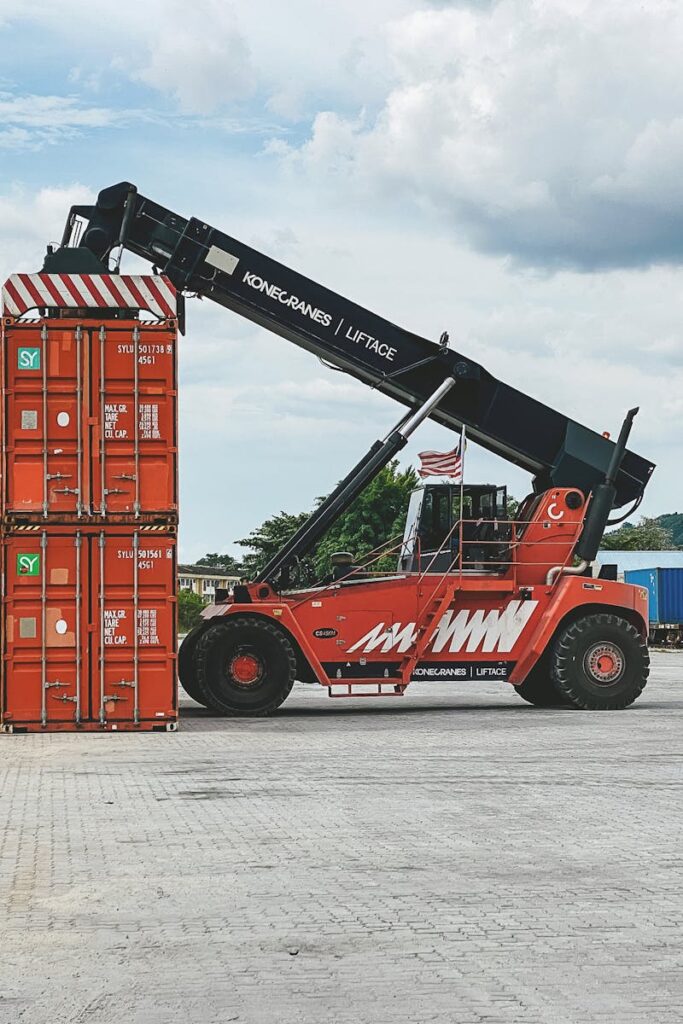 pexels photo 18928155 18928155 Red industrial crane lifting stacked cargo containers at a container yard in Ipoh, Malaysia.